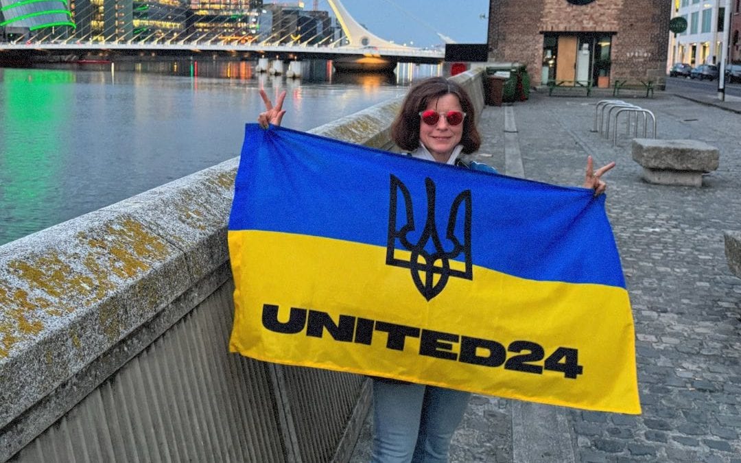 Донорка UNITED24 з Німеччини під час подорожей розгортає український стяг