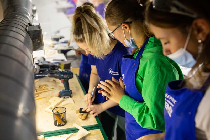 Молодь у майстерні працює з деревом під час практичного заняття