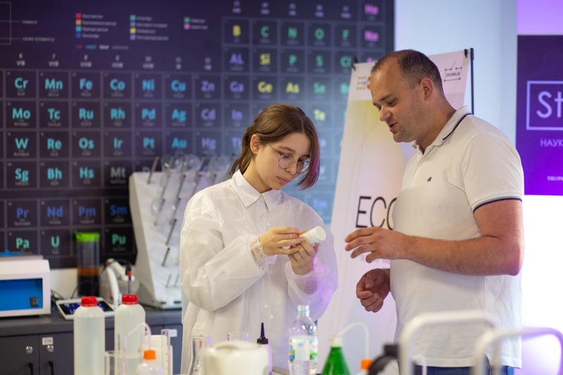 Студентка у лабораторії вивчає зразок під керівництвом викладача